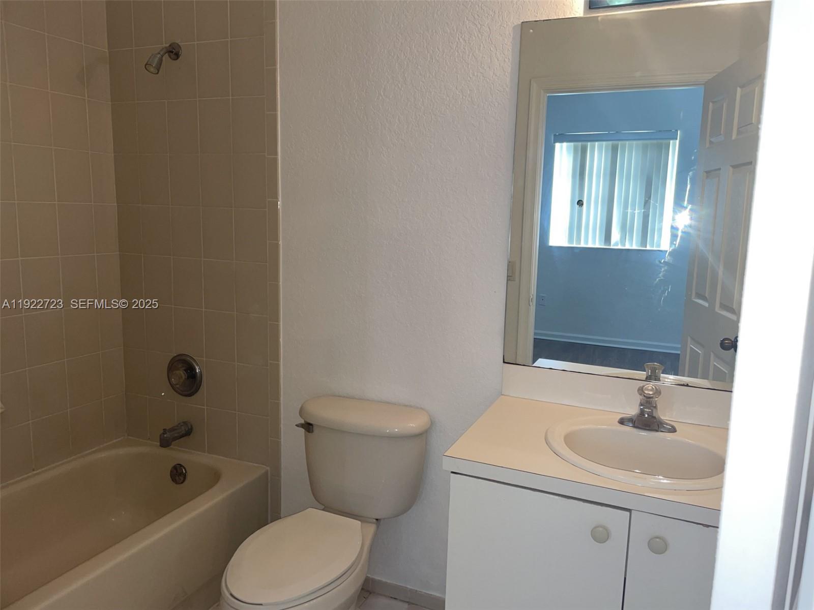 8831 South Isles Circle, Unit 8831 Tamarac, FL 33321 - Photo 20 of 22 a bathroom with a sink toilet and shower