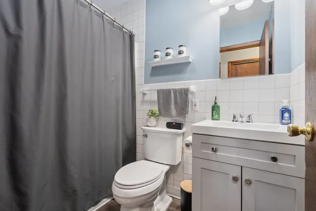 a bathroom with a sink a toilet and shower curtain