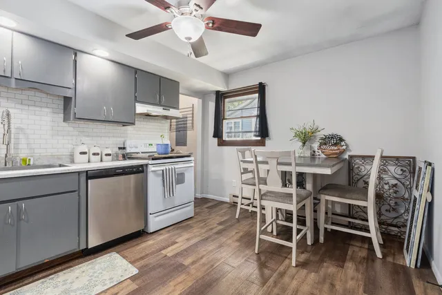 a kitchen with stainless steel appliances a table chairs refrigerator and cabinets
