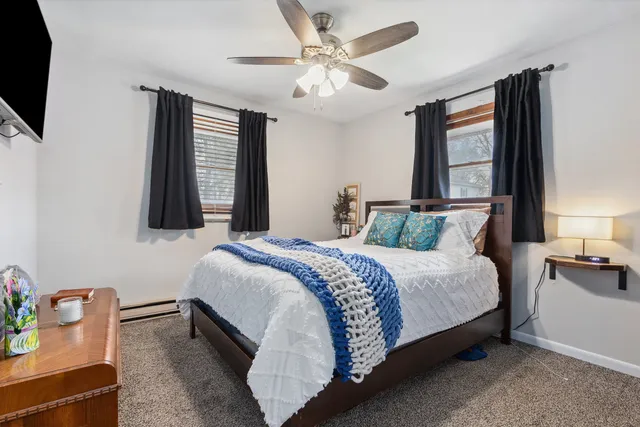 a bedroom with a bed a window and dresser