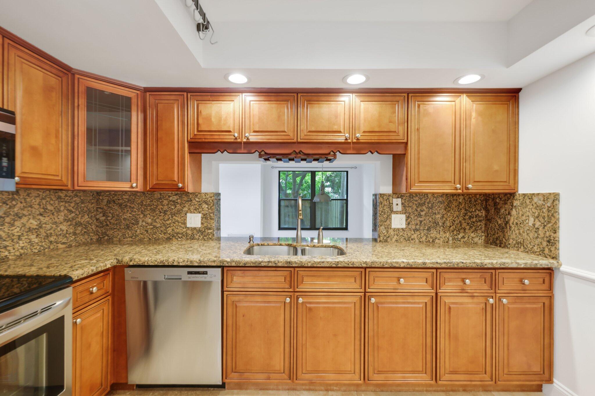 361 West Camino Real, Unit 9 Boca Raton, FL 33432 - Photo 13 of 37 a kitchen with granite countertop a sink and cabinets