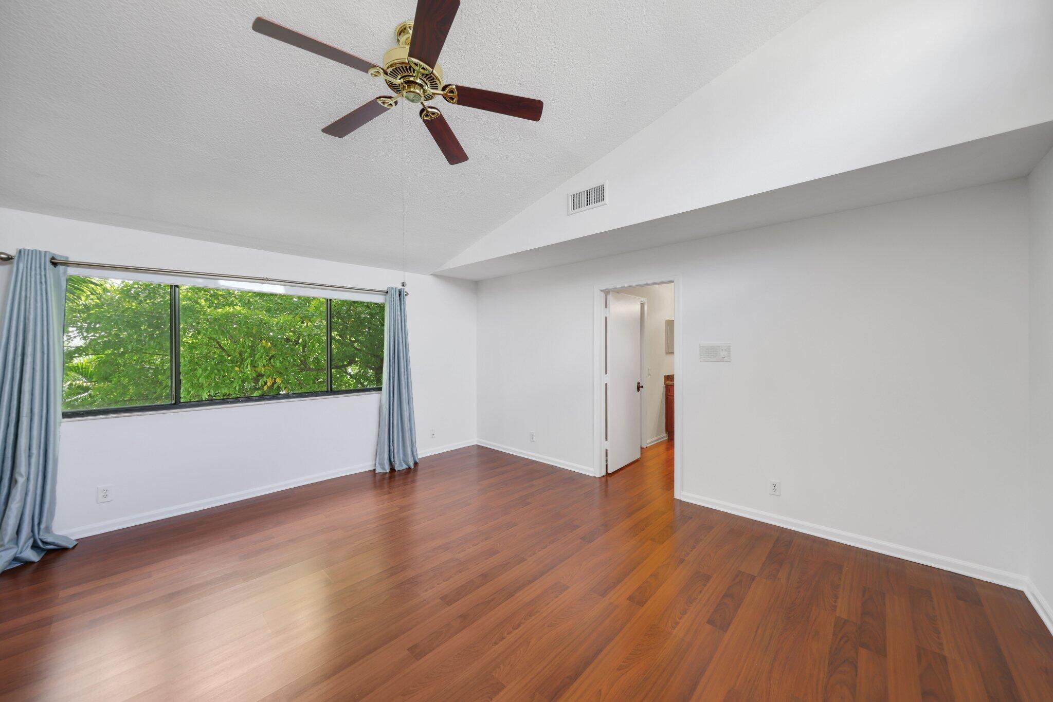 361 West Camino Real, Unit 9 Boca Raton, FL 33432 - Photo 20 of 37 an empty room with wooden floor fan and windows