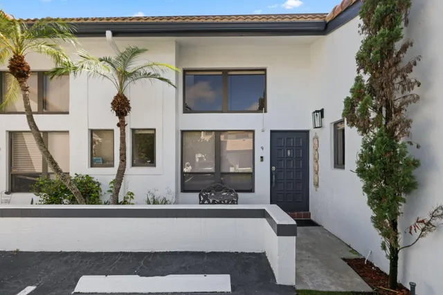 a view of a house with a window and potted plants