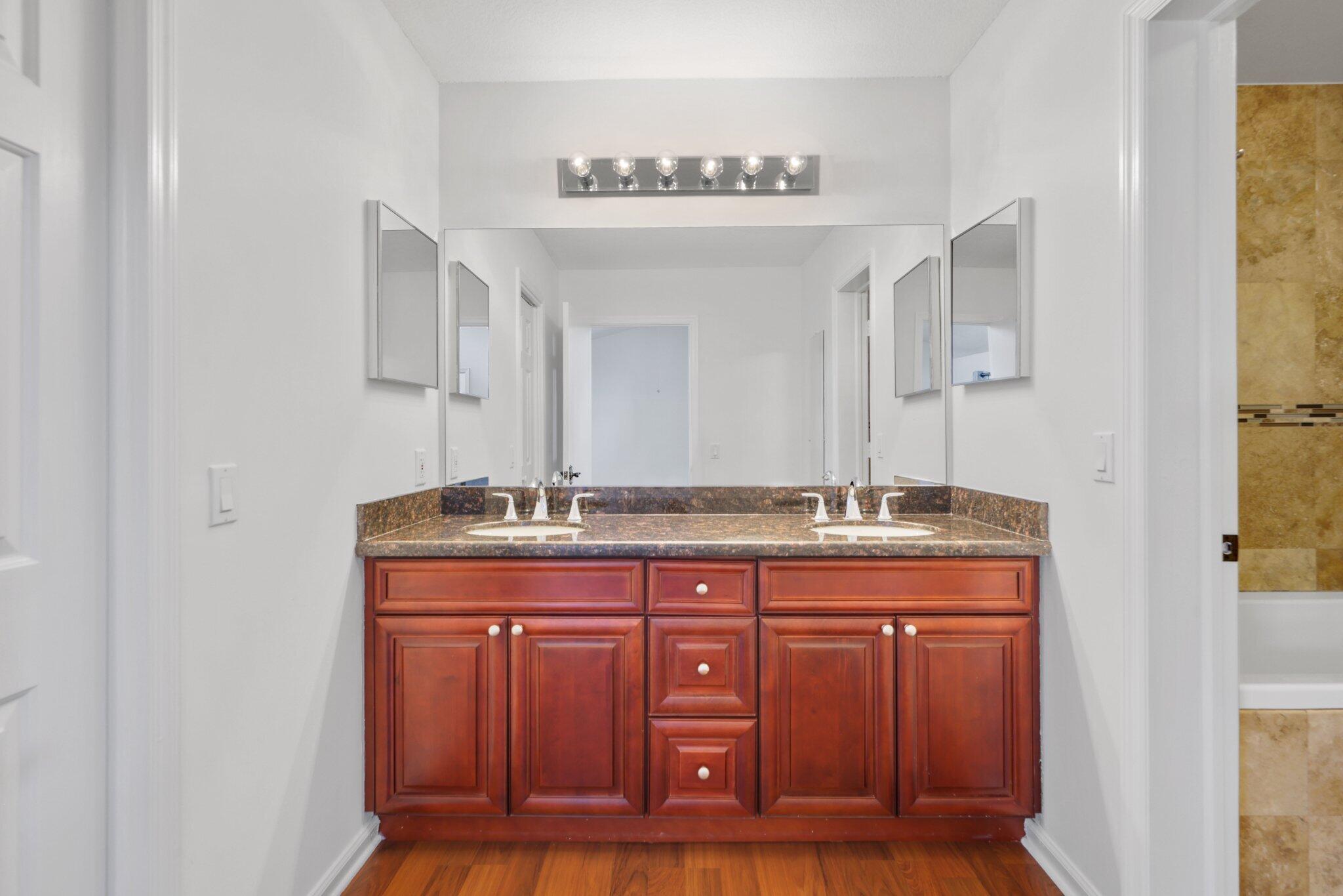 361 West Camino Real, Unit 9 Boca Raton, FL 33432 - Photo 22 of 37 a bathroom with a granite countertop sink and a mirror