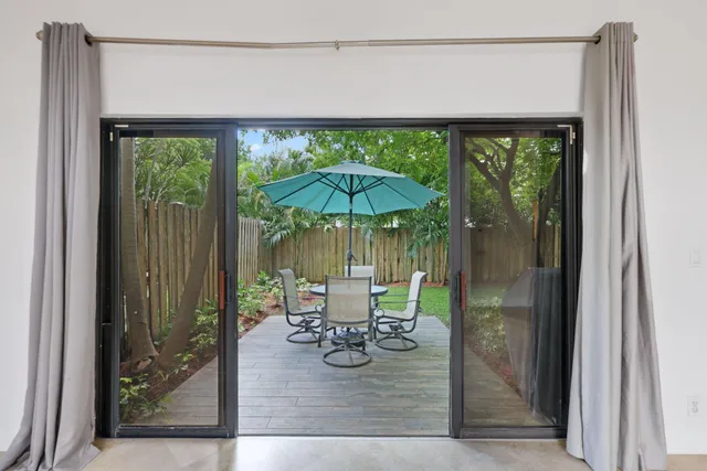 a view of a backyard with large trees and wooden fence