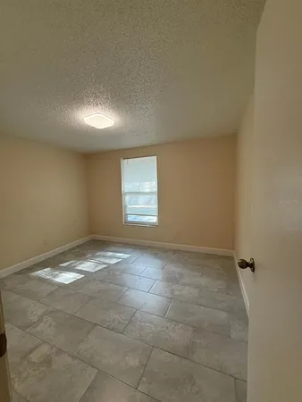 a view of a hallway with wooden floor and a bathroom