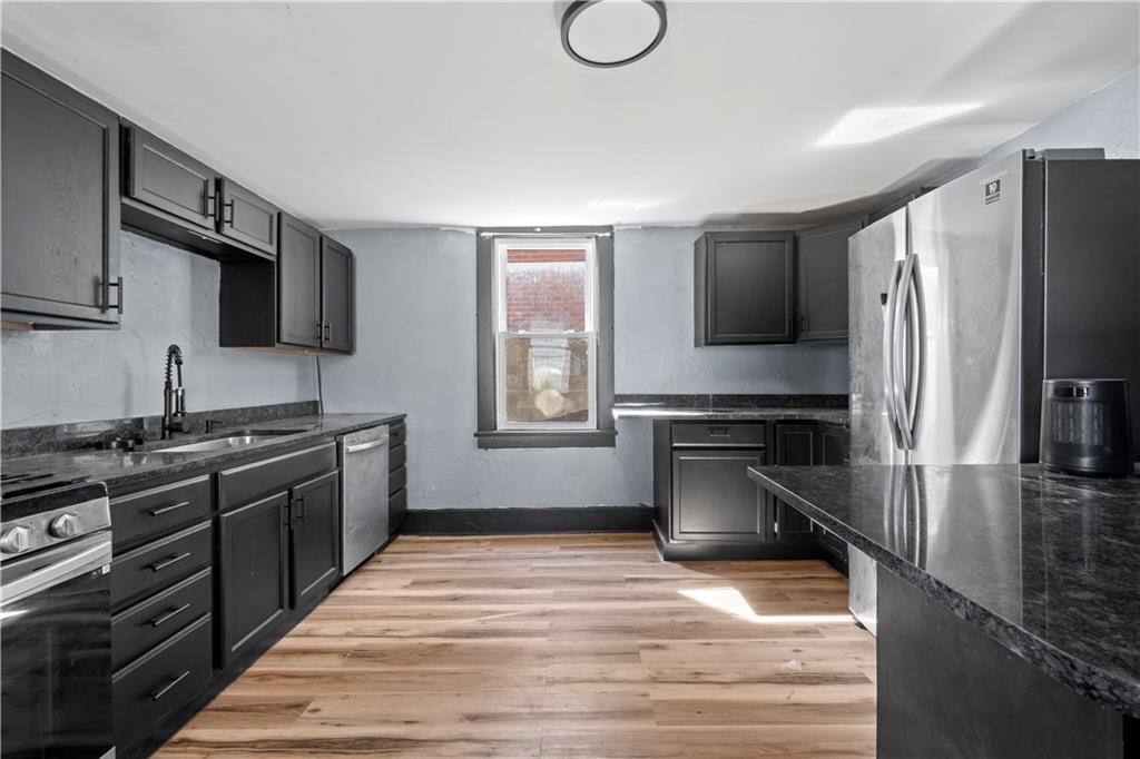 813 Bower Hill Road Bridgeville, PA 15017 - Photo 2 of 13 a kitchen with a refrigerator stove and sink