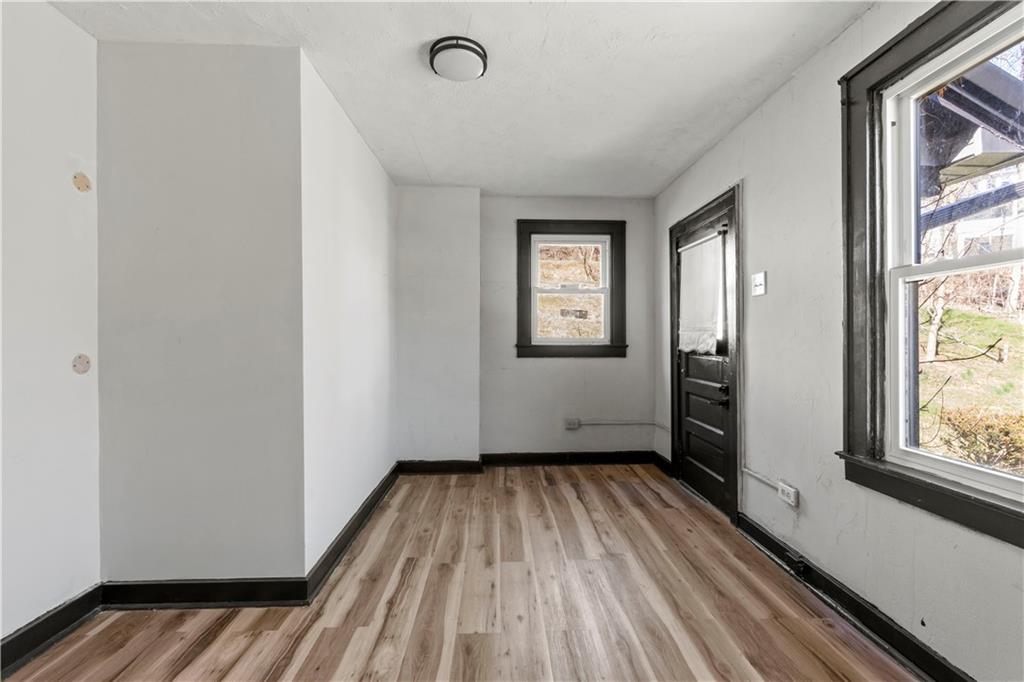 813 Bower Hill Road Bridgeville, PA 15017 - Photo 6 of 13 a view of an empty room with a window and wooden floor