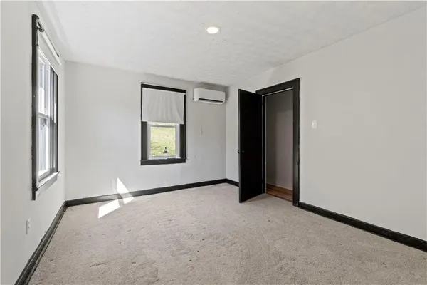 an empty room with windows and closet