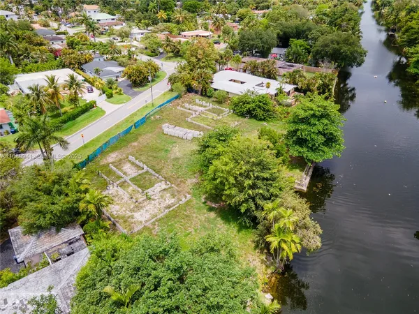 an aerial view of residential house with outdoor space and trees all around