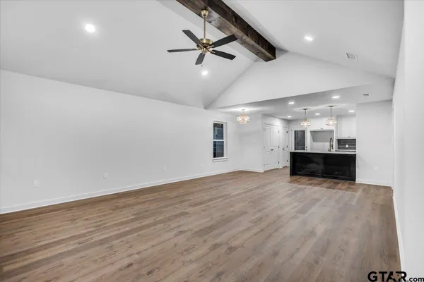 an empty room with wooden floor and ceiling fan