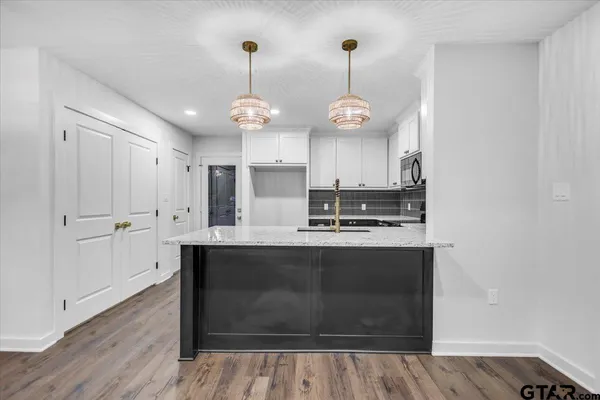 a view of dining room with wooden floor and chandelier