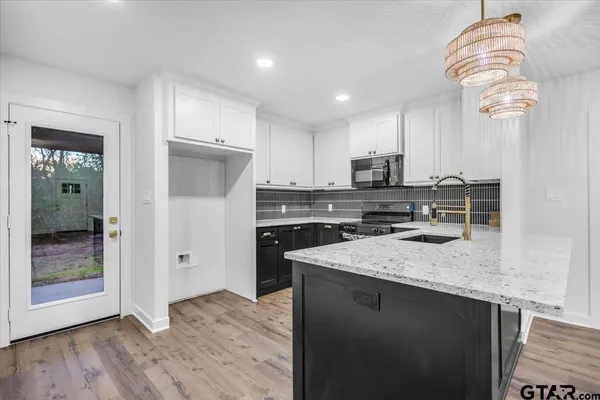 a kitchen with a sink a microwave a refrigerator and cabinets