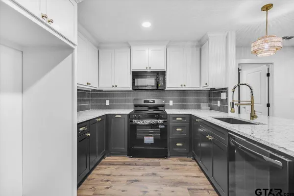 a kitchen with stainless steel appliances granite countertop a stove sink and cabinets