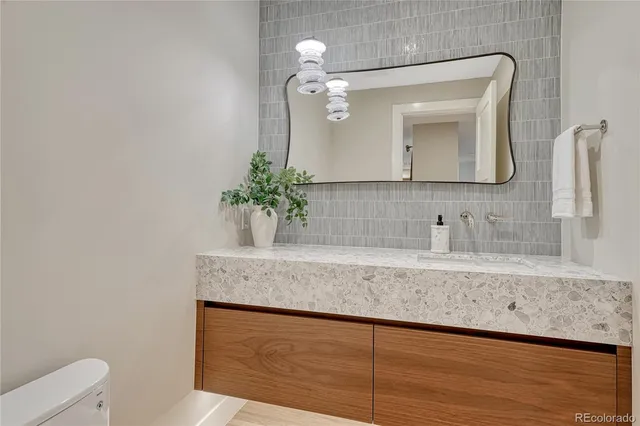 a bathroom with a granite countertop sink a mirror and vanity