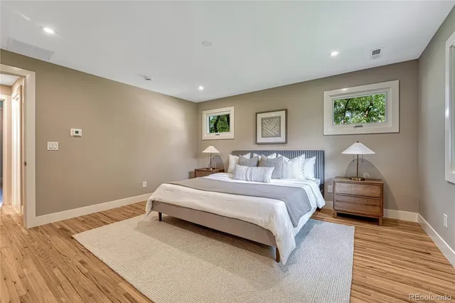 a spacious bedroom with a bed and a painting on the wall