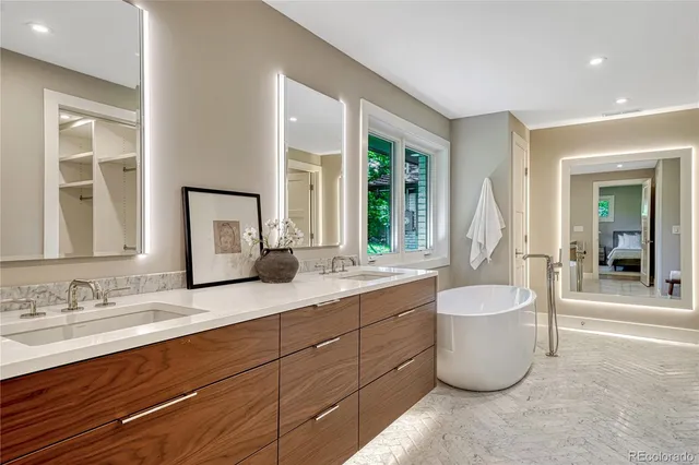 a spacious bathroom with a granite countertop sink and a bathtub