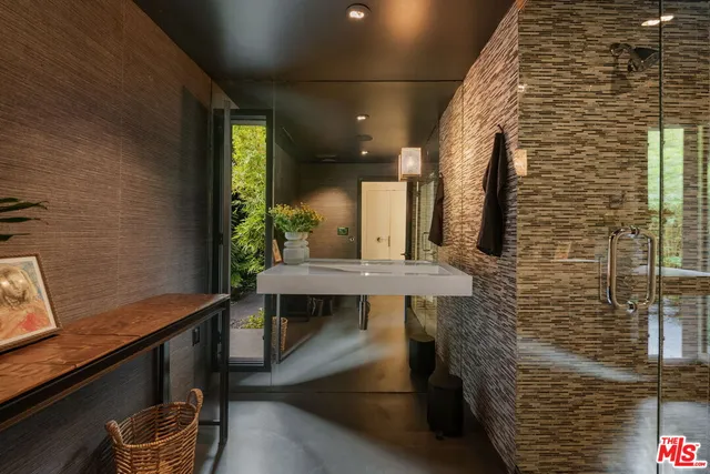 a bedroom with a bed and a flat tv screen next to a large window