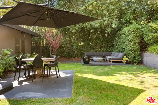 a view of a patio with table and chairs under an umbrella