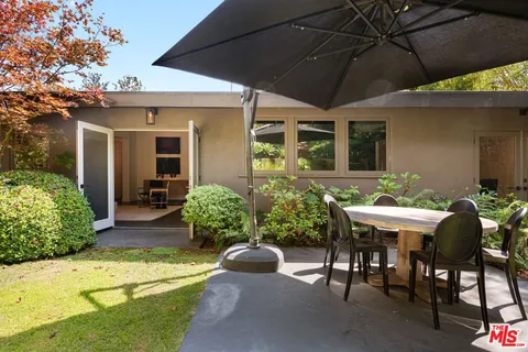a view of a patio with chairs and plants