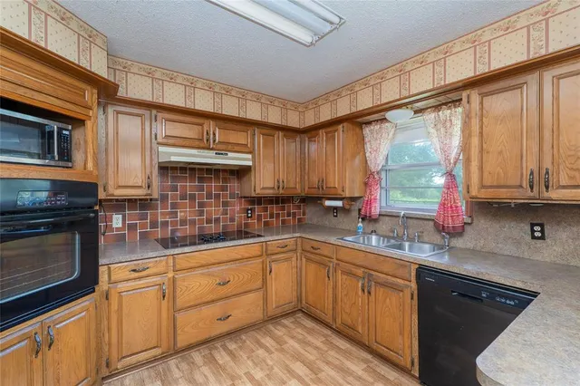 a kitchen with stainless steel appliances granite countertop a sink stove and cabinets