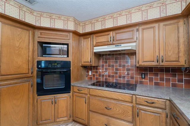 a kitchen with granite countertop white cabinets and stainless steel appliances