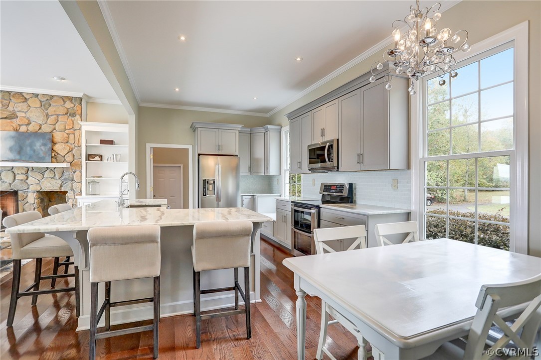 5149 Wakema Road West Point, VA 23181 - Photo 5 of 47 a kitchen with stainless steel appliances granite countertop a dining table chairs stove refrigerator and microwave