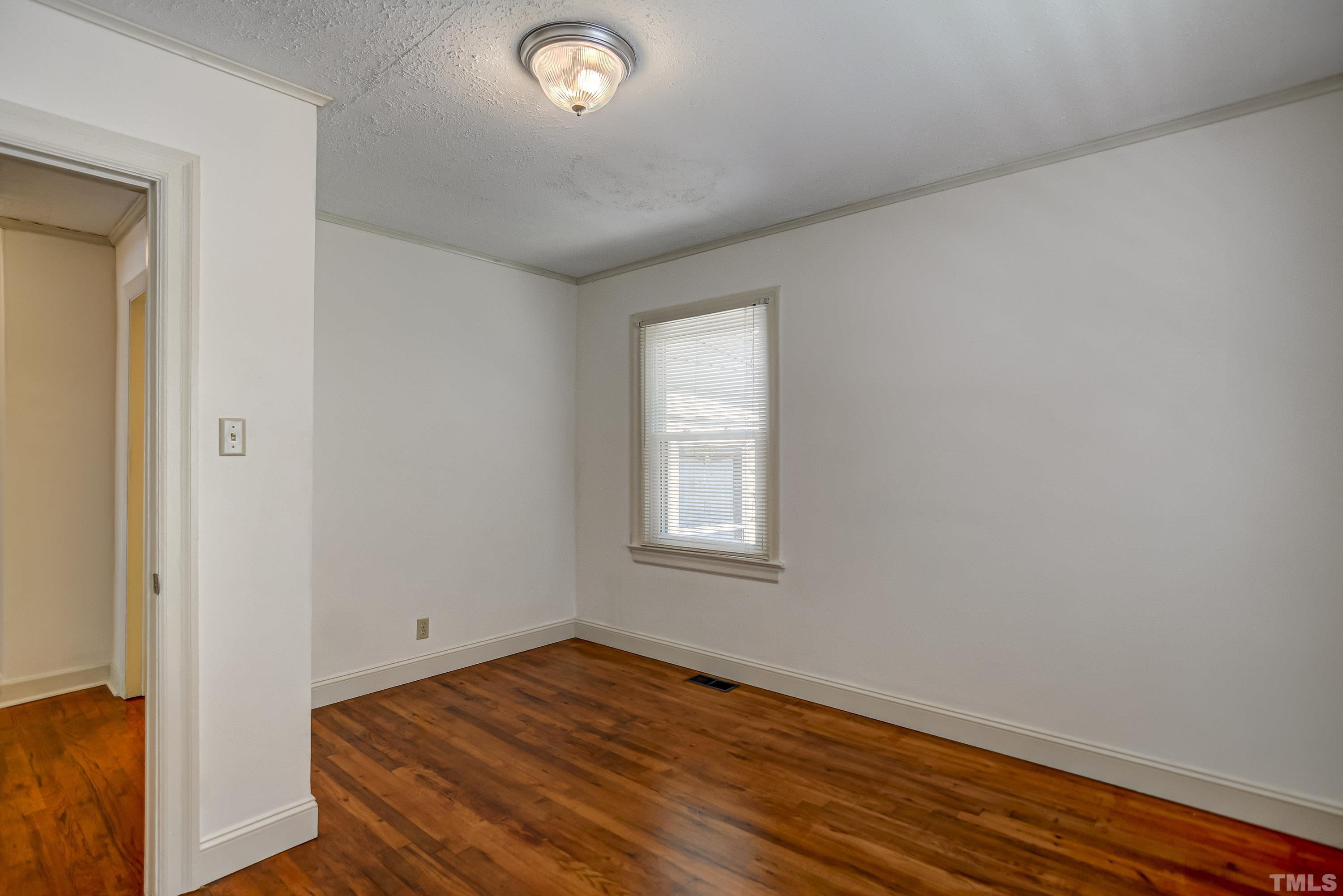 207 Myers Avenue Raleigh, NC 27604 - Photo 15 of 26 an empty room with wooden floor and windows
