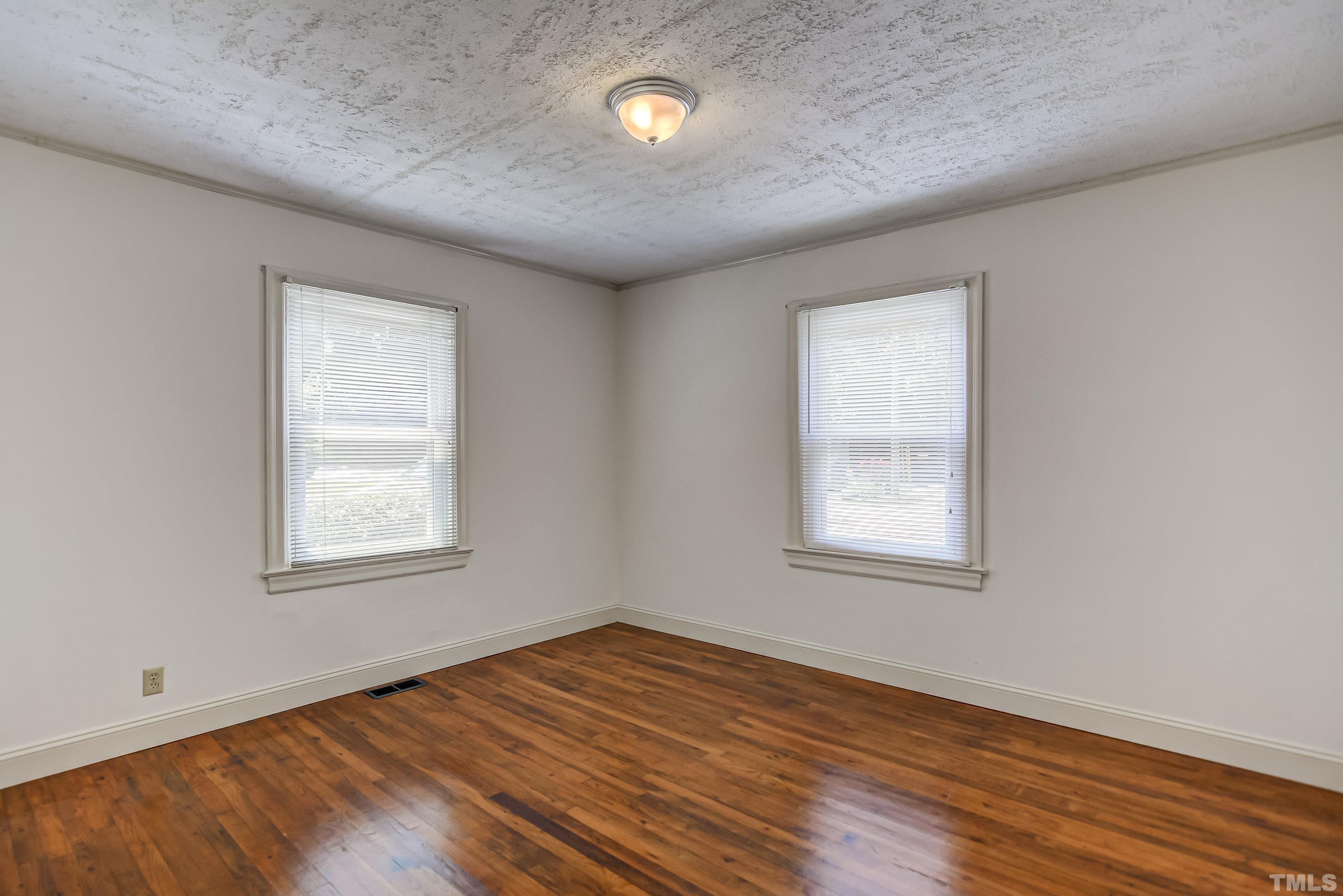 207 Myers Avenue Raleigh, NC 27604 - Photo 17 of 26 an empty room with wooden floor and windows