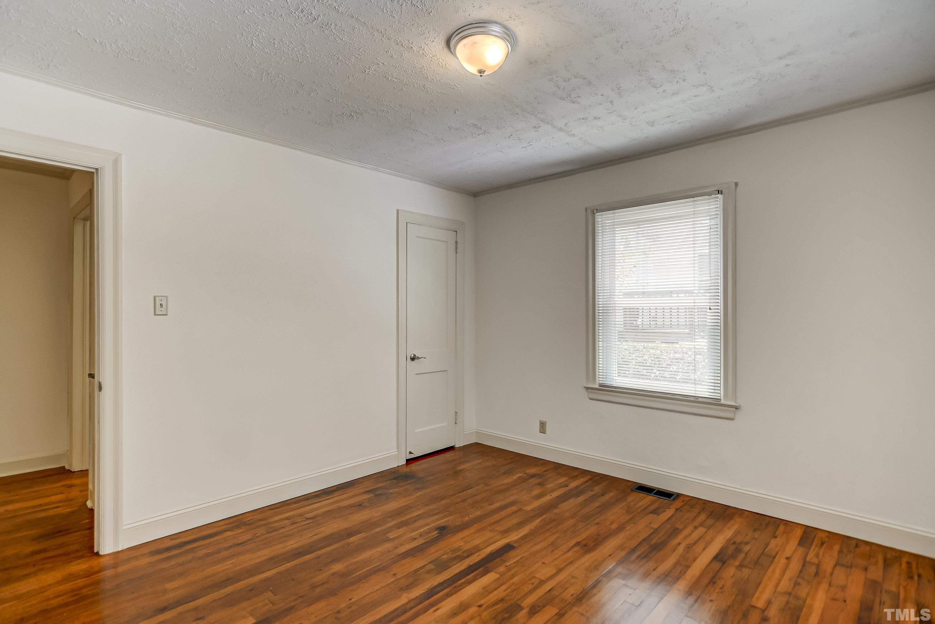 207 Myers Avenue Raleigh, NC 27604 - Photo 18 of 26 an empty room with wooden floor and windows