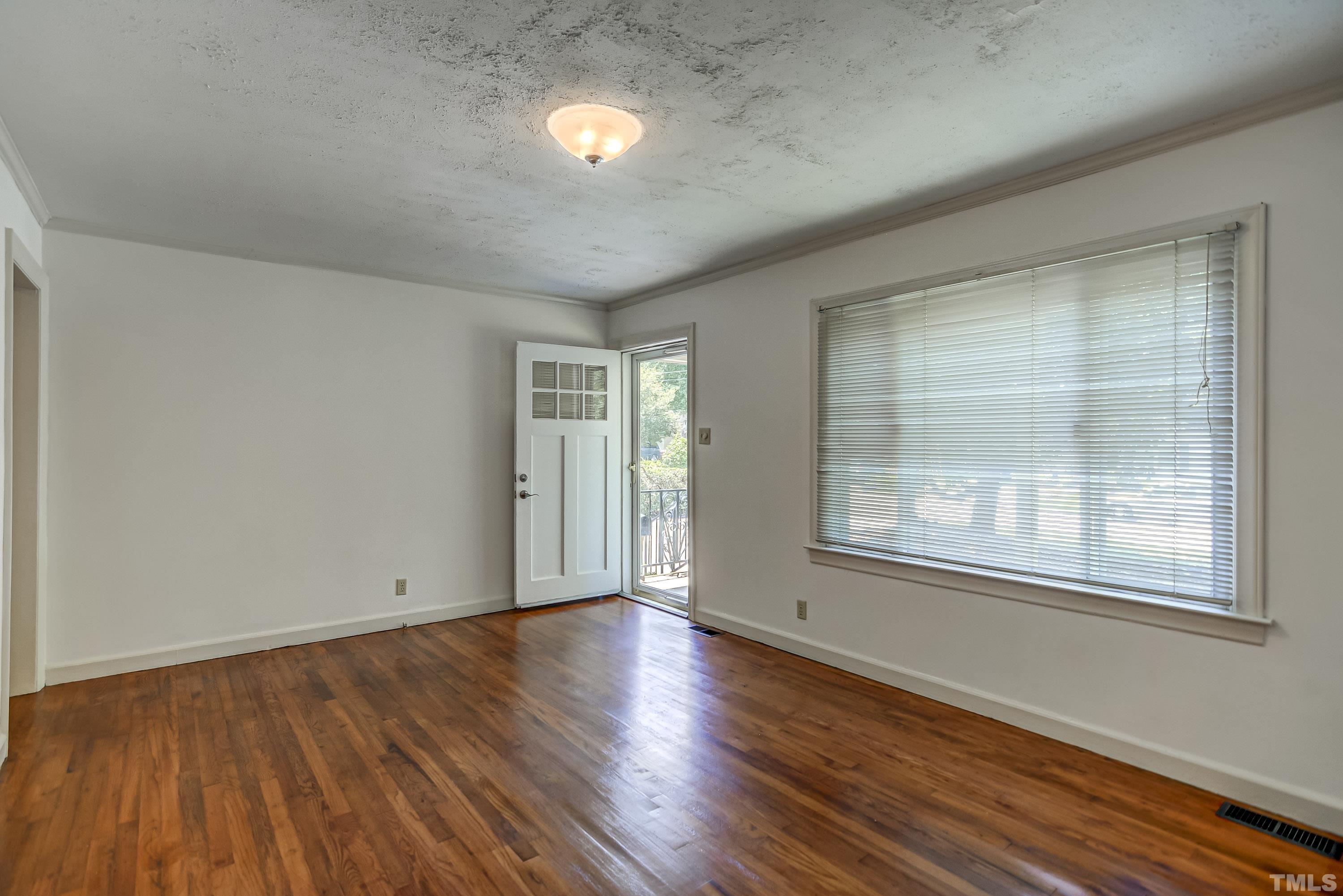 207 Myers Avenue Raleigh, NC 27604 - Photo 7 of 26 an empty room with wooden floor and windows