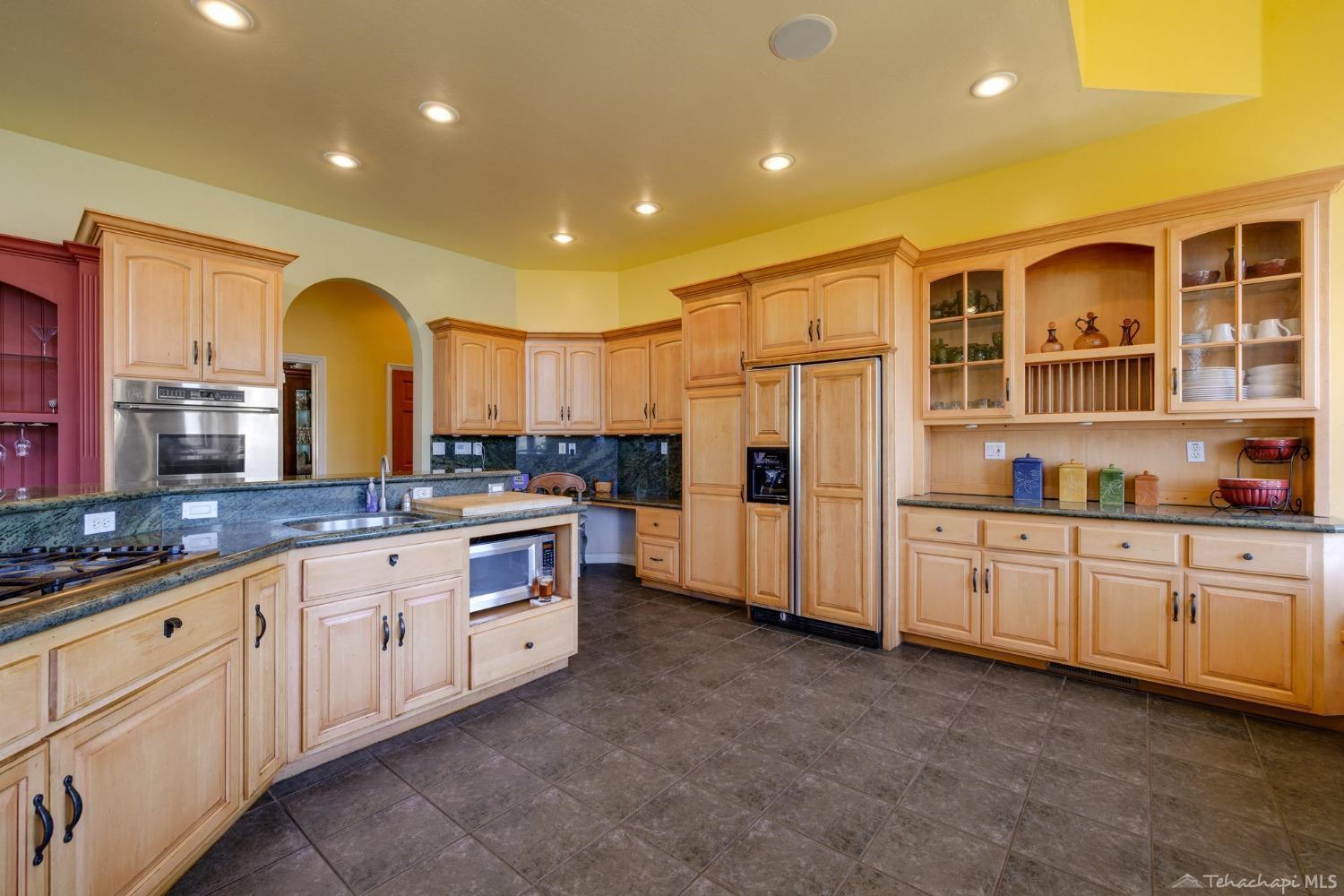 24500 Heather Court Tehachapi, CA 93561 - Photo 21 of 60 a large kitchen with stainless steel appliances granite countertop a stove a sink and a refrigerator