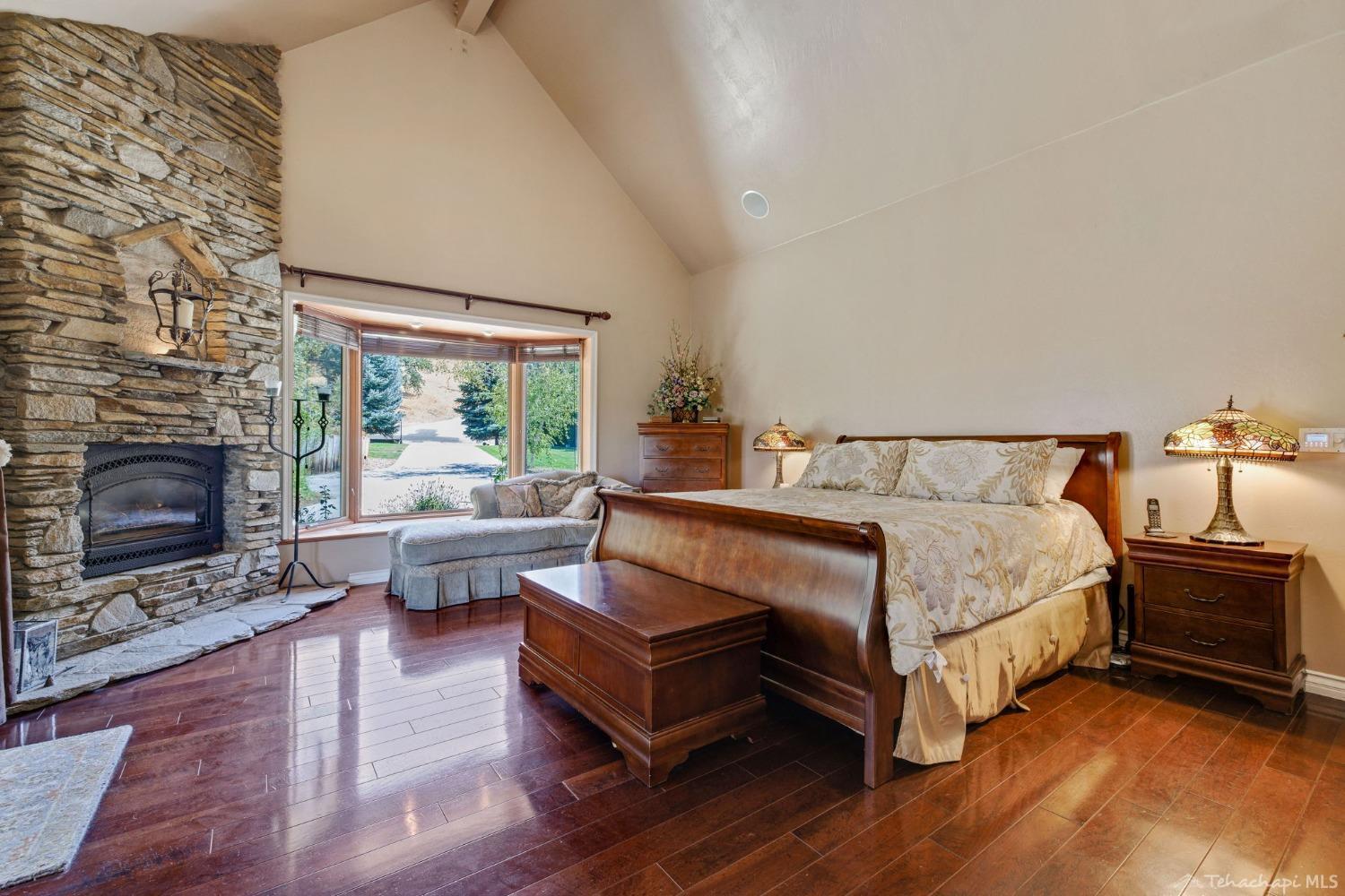 24500 Heather Court Tehachapi, CA 93561 - Photo 24 of 60 a spacious bedroom with a bed and a fireplace
