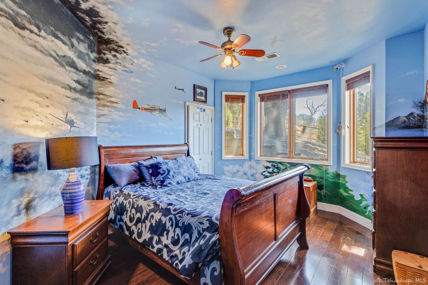 24500 Heather Court Tehachapi, CA 93561 - Photo 43 of 60 a bedroom with a bed and wooden floor