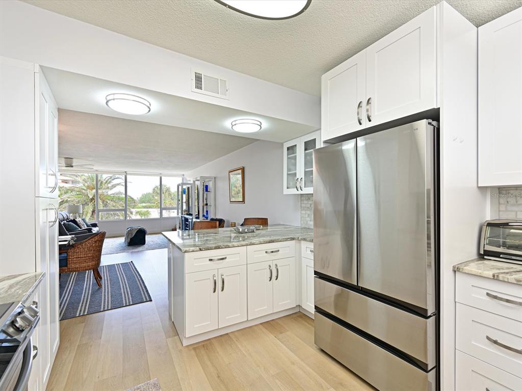 100 Sands Point Road, Unit 225 Longboat Key, FL 34228 - Photo 14 of 32 a kitchen with a refrigerator a sink and a stove top oven