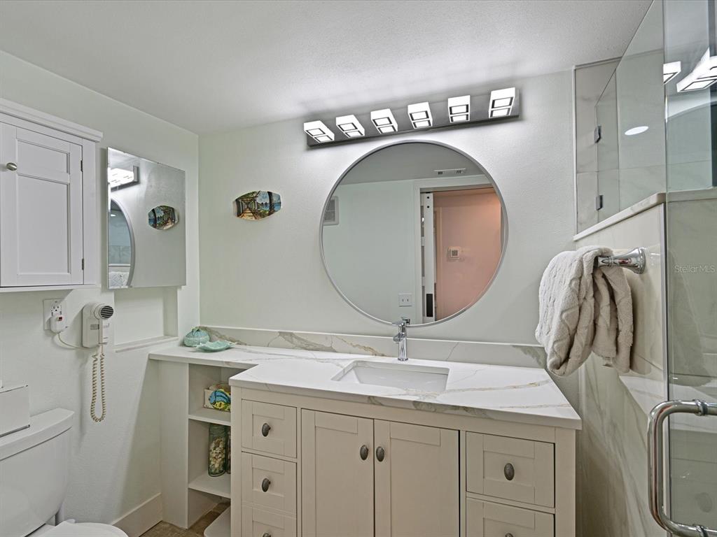 100 Sands Point Road, Unit 225 Longboat Key, FL 34228 - Photo 17 of 32 a bathroom with a double vanity sink and a mirror