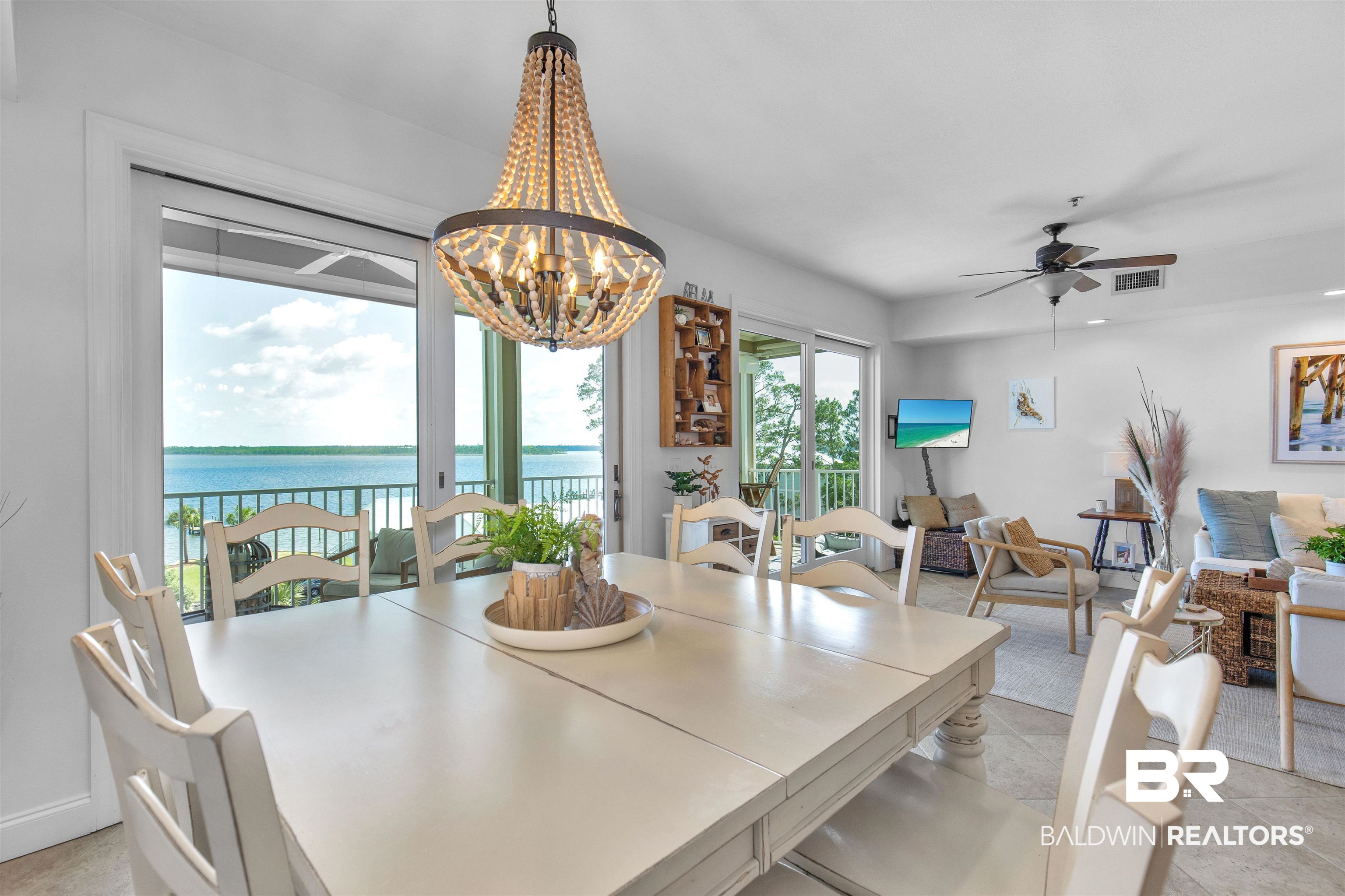25909 Canal Road, Unit 301 Orange Beach, AL 36561 - Photo 3 of 43 Dining area featuring a water view and ceiling fan with notable chandelier