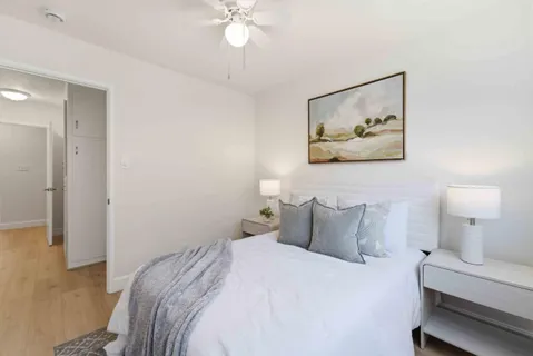 a bedroom with a bed and a painting on the wall