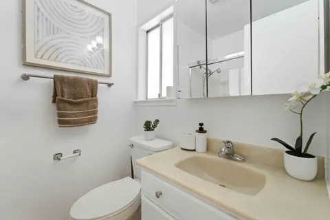 a bathroom with a toilet sink and mirror