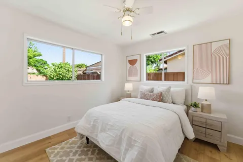 a bedroom with a bed chandelier and a window