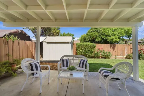 a view of a patio with table and chairs potted plants with wooden fence