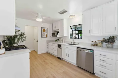 a kitchen with cabinets a sink and appliances