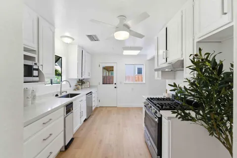 a kitchen with sink a stove and cabinets