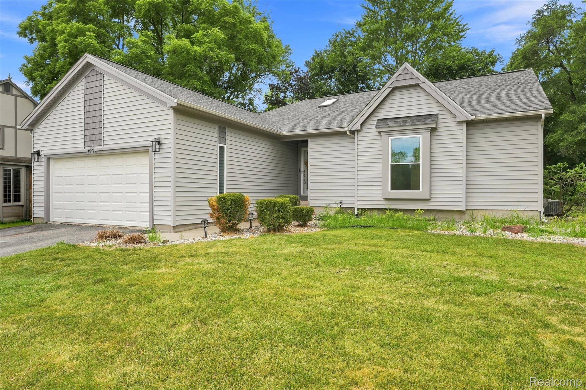 793 North Adams Road Rochester, MI 48309 - Photo 2 of 40 Exterior featuring light gray siding, a two-car garage, a bay window, and a gabled roofline