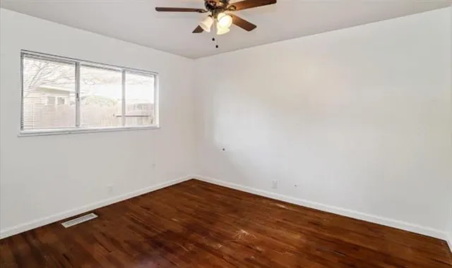 wooden floor in an empty room with a window