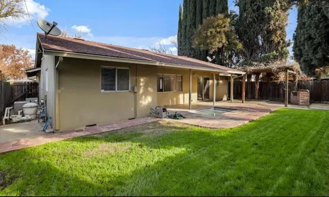 a backyard of a house with table and chairs