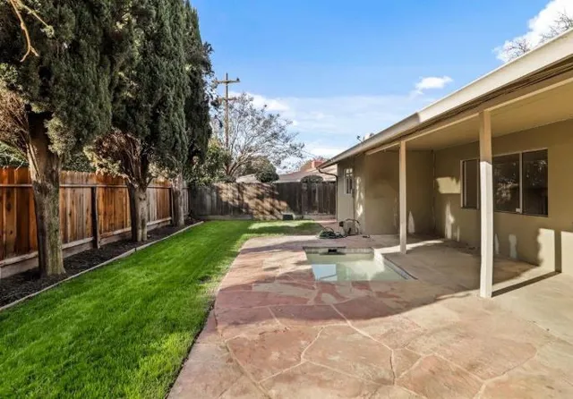 a view of a house with backyard and sitting area