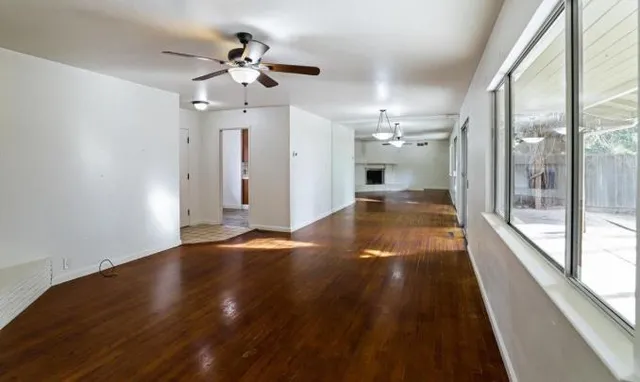 wooden floor in an empty room with a large window