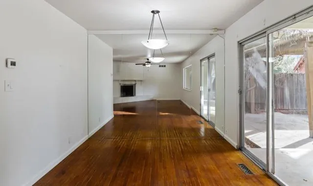 a view of a hallway with wooden floor and a chandelier