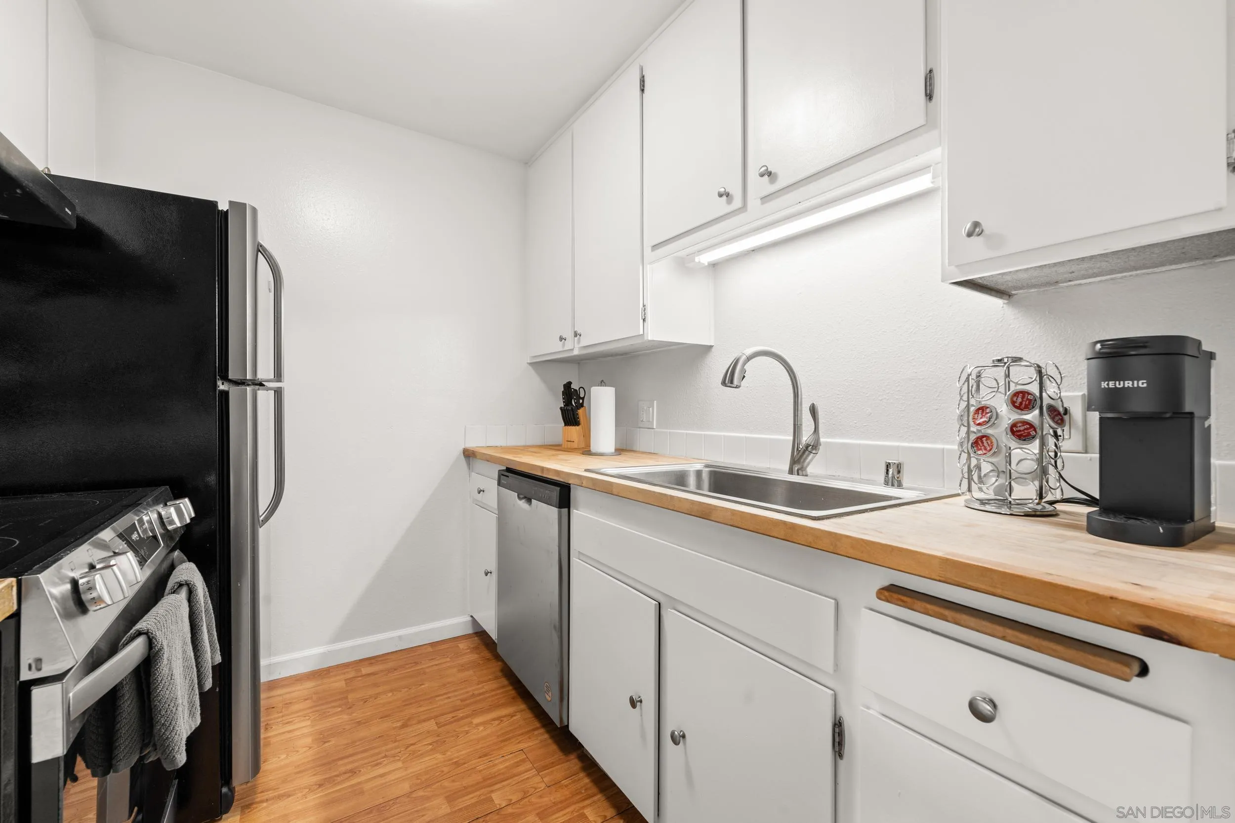 6202 Friars Road, Unit 215 San Diego, CA 92108 - Photo 3 of 18 a kitchen with stainless steel appliances granite countertop a sink stove and refrigerator